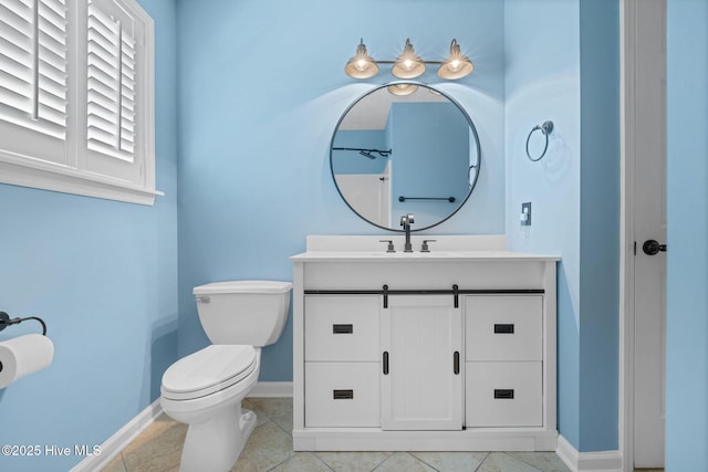 bathroom with toilet, vanity, and baseboards