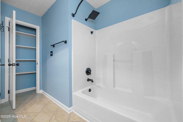 full bathroom with a walk in closet, shower / bathtub combination, a textured ceiling, tile patterned flooring, and baseboards