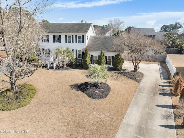 view of front of property with concrete driveway and fence