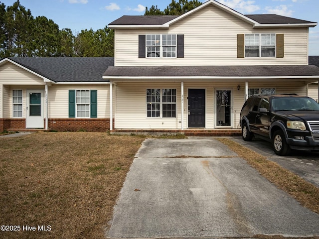 view of front of home featuring covered porch, brick siding, a front yard, and a shingled roof