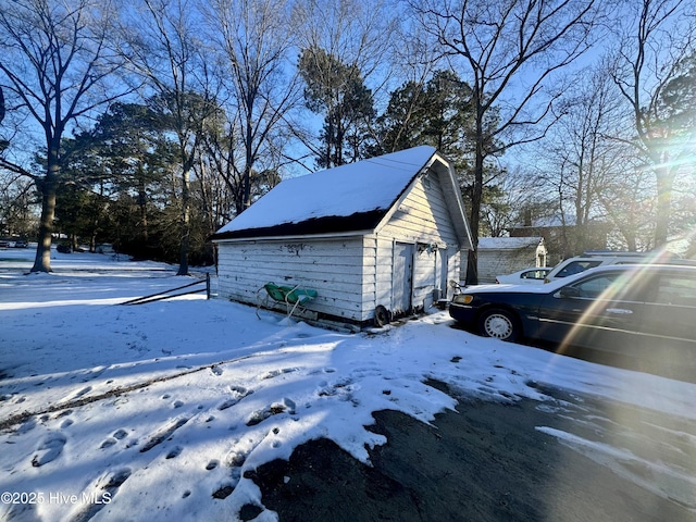 snow covered garage with a detached garage