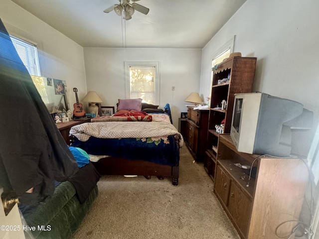 bedroom featuring light carpet and a ceiling fan