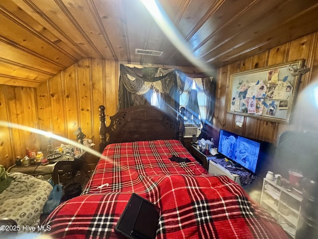 bedroom with wooden ceiling, visible vents, vaulted ceiling, and wooden walls