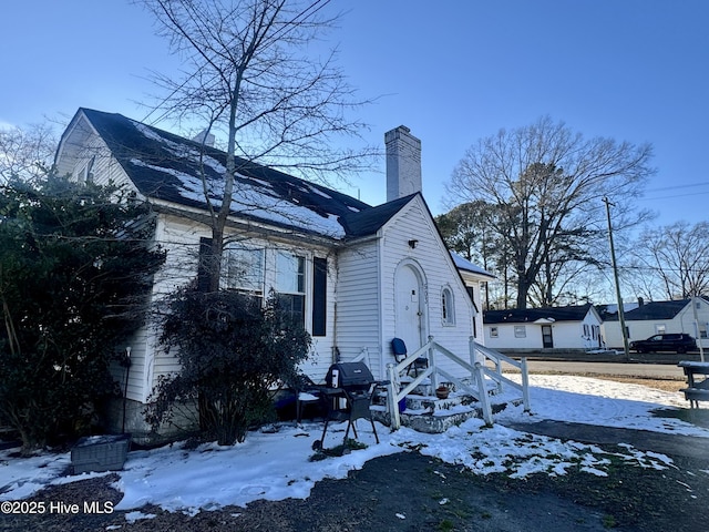 view of snow covered exterior featuring a chimney