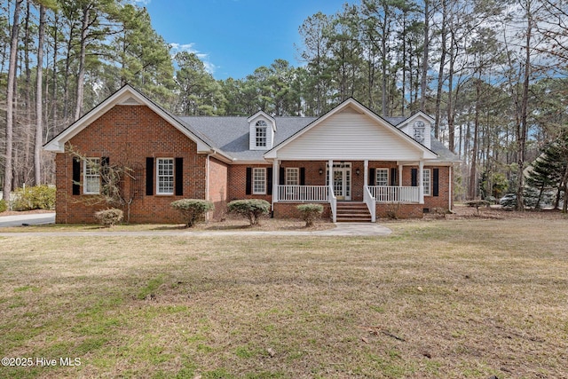 view of front of house with covered porch, brick siding, and a front lawn