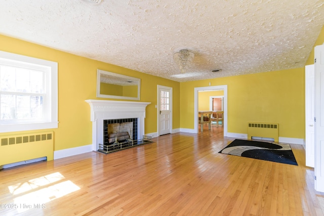 living room with a fireplace with flush hearth, wood finished floors, and radiator