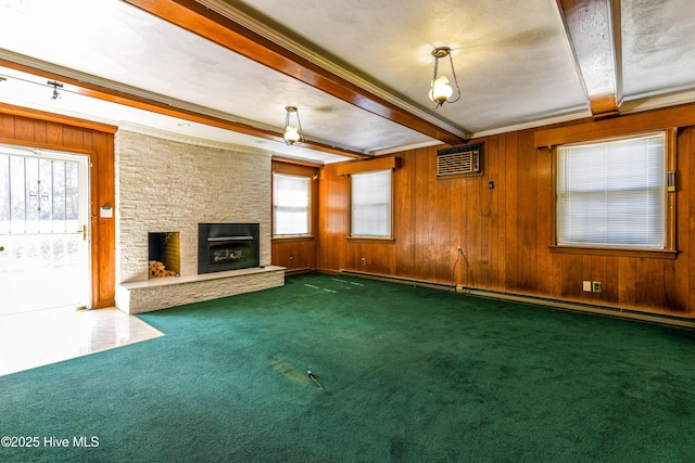 unfurnished living room featuring wooden walls, a fireplace, beam ceiling, dark colored carpet, and a wall mounted air conditioner