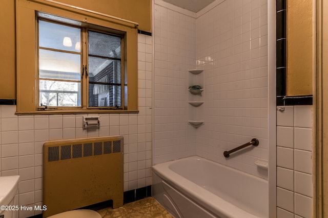 bathroom featuring toilet, radiator heating unit, and tile walls