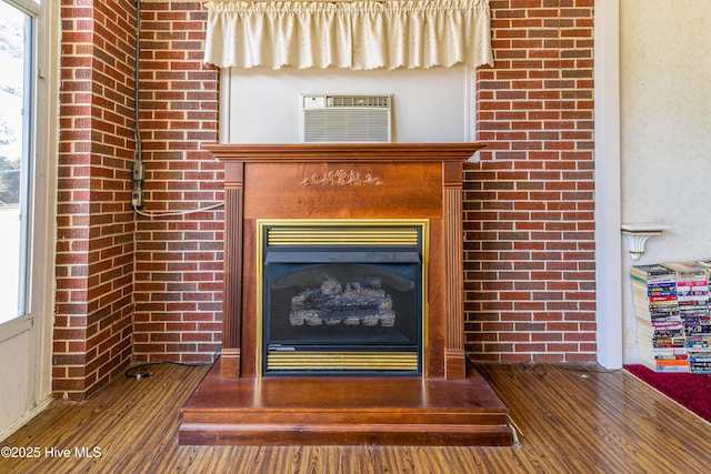 details with a fireplace, wood finished floors, and a wall mounted AC