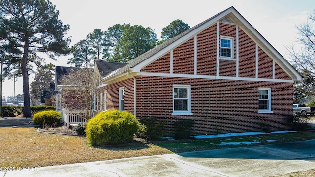 view of home's exterior featuring a shingled roof and brick siding