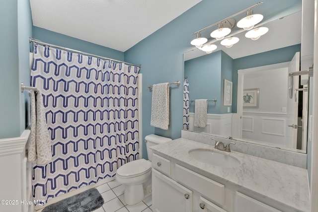 full bathroom featuring toilet, a wainscoted wall, a shower with shower curtain, vanity, and tile patterned floors