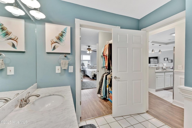 bathroom with tile patterned flooring, connected bathroom, two vanities, and a sink