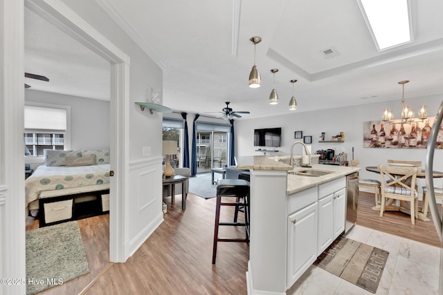 kitchen featuring visible vents, dishwasher, open floor plan, hanging light fixtures, and a sink