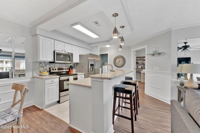 kitchen featuring light wood finished floors, visible vents, appliances with stainless steel finishes, and white cabinets