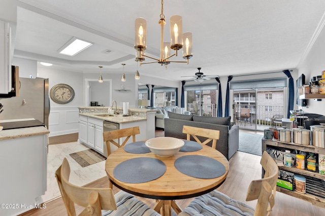 dining space with light wood-style floors, a decorative wall, and a wealth of natural light