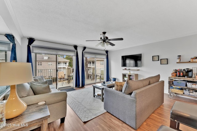 living area featuring ceiling fan, a textured ceiling, and wood finished floors