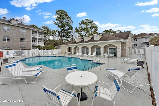 community pool with fence and a patio