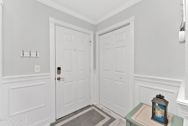 doorway to outside with a wainscoted wall and crown molding