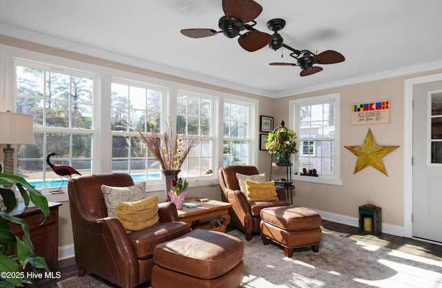 living area featuring ornamental molding, wood finished floors, and baseboards