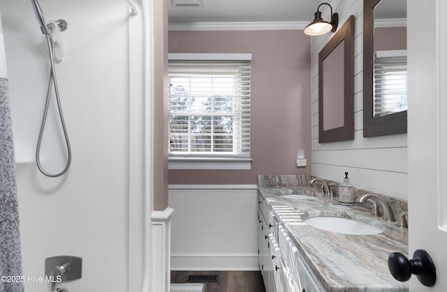 full bathroom with ornamental molding, a sink, and a wealth of natural light