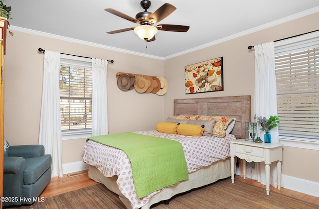 bedroom with baseboards, ceiling fan, wood finished floors, and crown molding