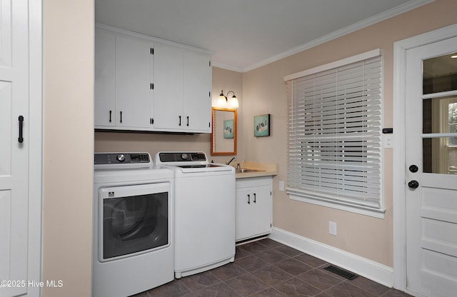 clothes washing area featuring cabinet space, visible vents, baseboards, crown molding, and washer and dryer