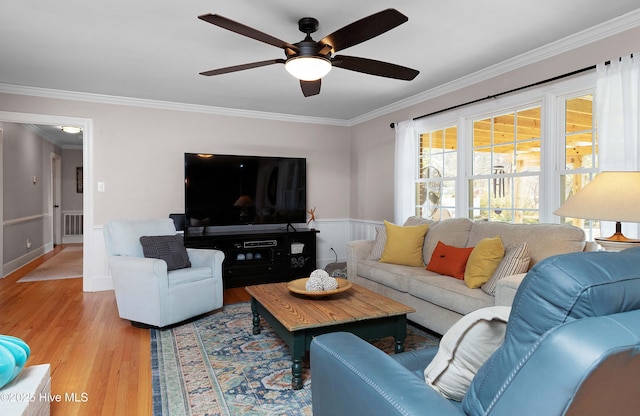 living room featuring visible vents, crown molding, and light wood-style flooring