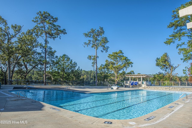 community pool with a patio area, fence, and a pergola