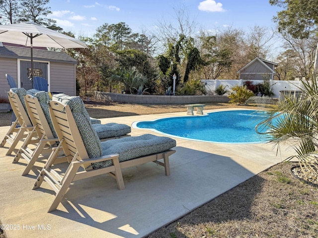 view of swimming pool featuring a fenced in pool, an outbuilding, a patio area, and fence