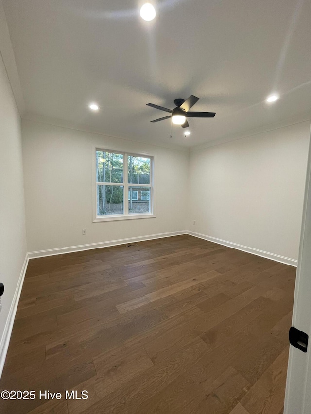 spare room with dark wood finished floors, recessed lighting, ornamental molding, a ceiling fan, and baseboards