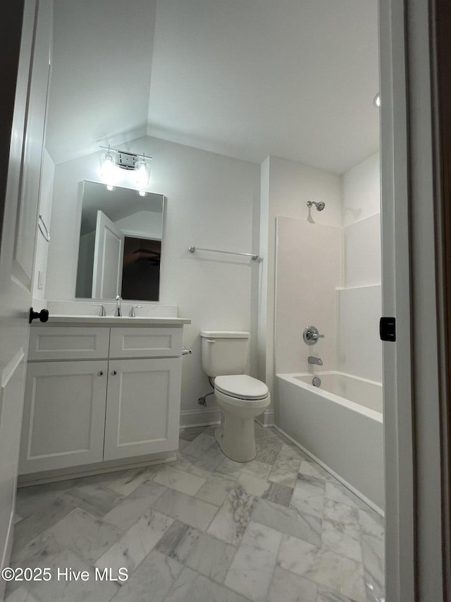 full bathroom featuring marble finish floor, toilet, washtub / shower combination, vaulted ceiling, and vanity