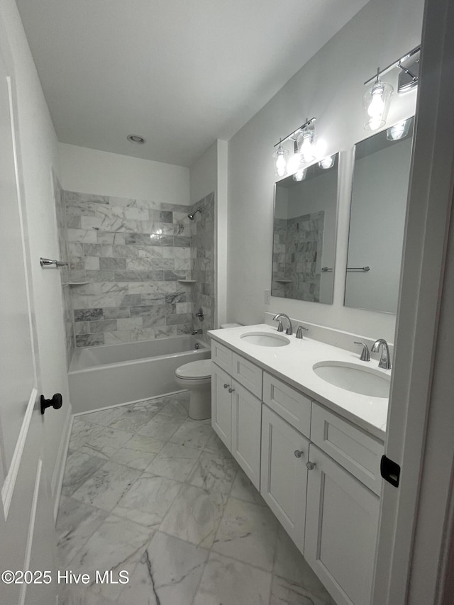 bathroom with toilet, marble finish floor, bathtub / shower combination, and a sink