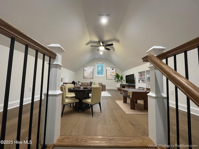 interior space featuring visible vents, ceiling fan, vaulted ceiling, wood finished floors, and baseboards