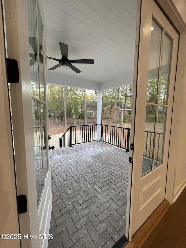 unfurnished sunroom featuring ceiling fan