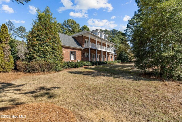 28 Beasley Dr, Pinehurst, NC 28374 - rear view of property with a balcony, a yard, and brick siding