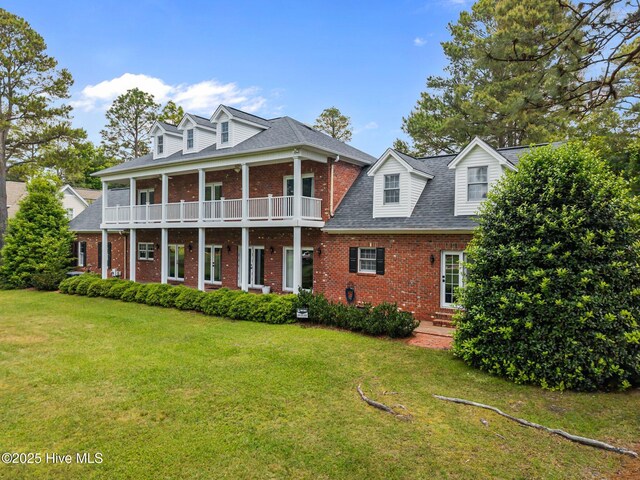 28 Beasley Dr, Pinehurst, NC 28374 - view of front facade with brick siding, a front yard, roof with shingles, and a balcony