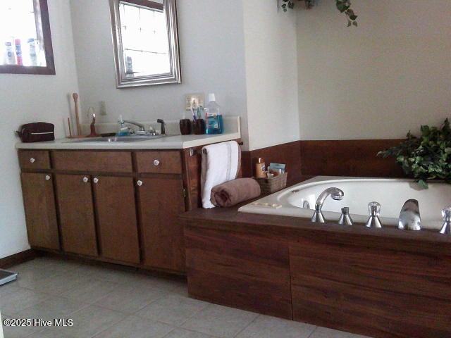 full bathroom featuring a sink, tile patterned flooring, and a washtub