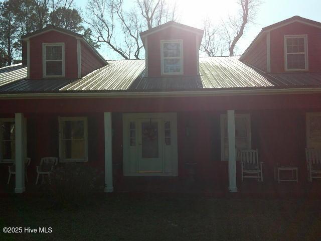 rear view of house with covered porch and metal roof