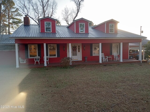 view of front of house featuring metal roof, a front lawn, and a porch