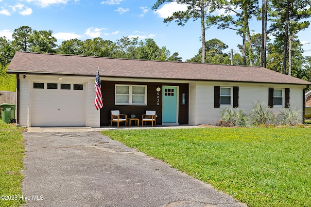 single story home with brick siding, aphalt driveway, an attached garage, covered porch, and a front yard