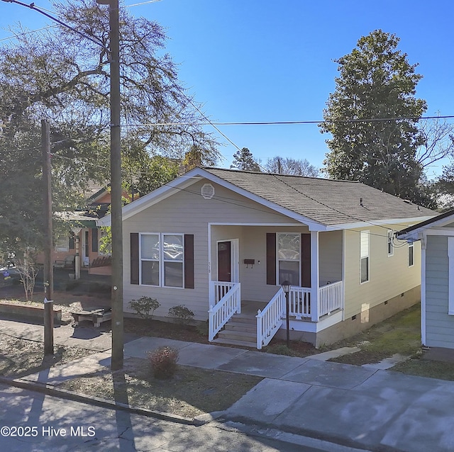 view of front of home with crawl space, covered porch, and a shingled roof