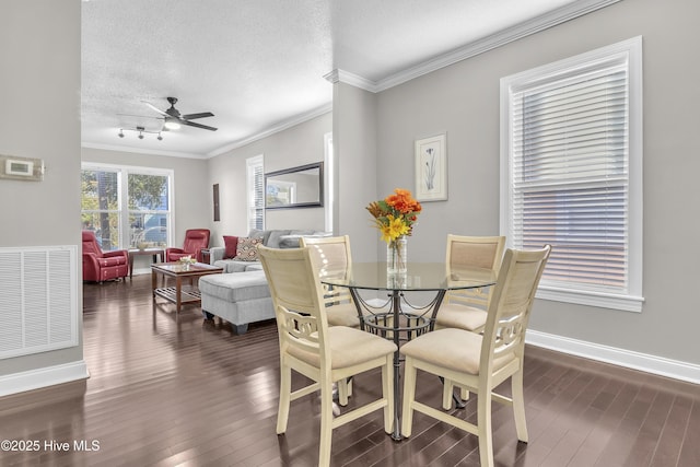 dining area with dark wood-style floors, ornamental molding, and visible vents