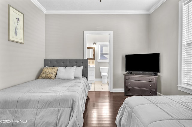 bedroom with baseboards, connected bathroom, ornamental molding, and wood finished floors