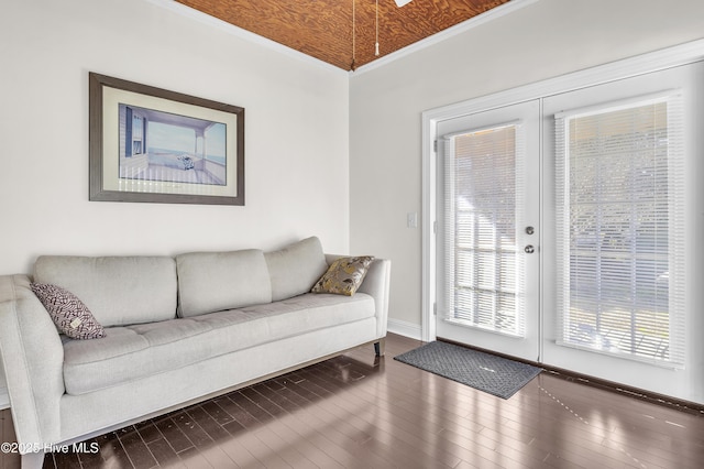 living area featuring ornamental molding, baseboards, and hardwood / wood-style flooring