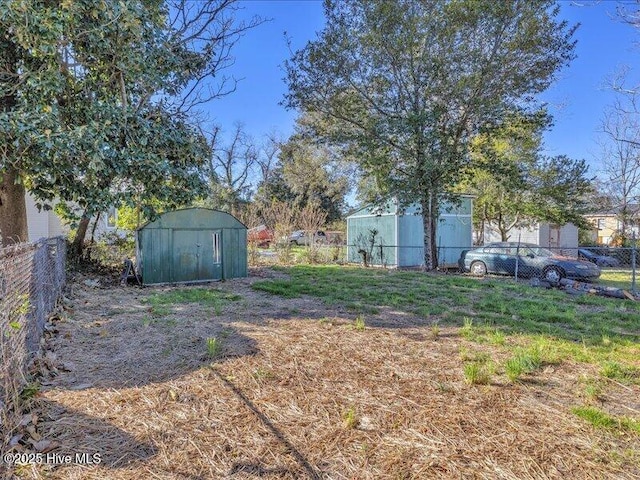 view of yard with an outbuilding, a shed, and fence