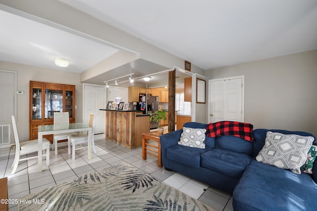 living area with rail lighting, light tile patterned flooring, and visible vents