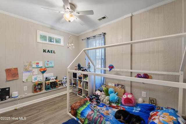 bedroom with a ceiling fan, crown molding, wood finished floors, and visible vents