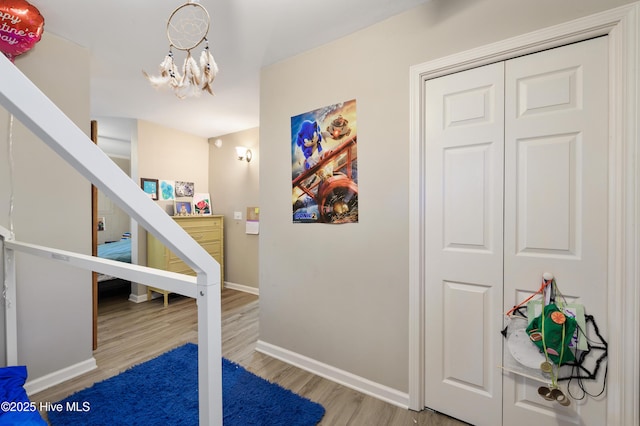 interior space featuring baseboards, an inviting chandelier, and wood finished floors