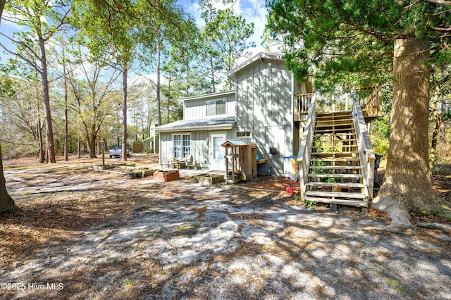 rear view of property with stairs and a deck