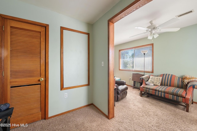 living area with visible vents, baseboards, a ceiling fan, and carpet flooring